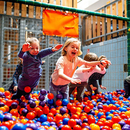 Speelpunt meisjes springen in ballenbad